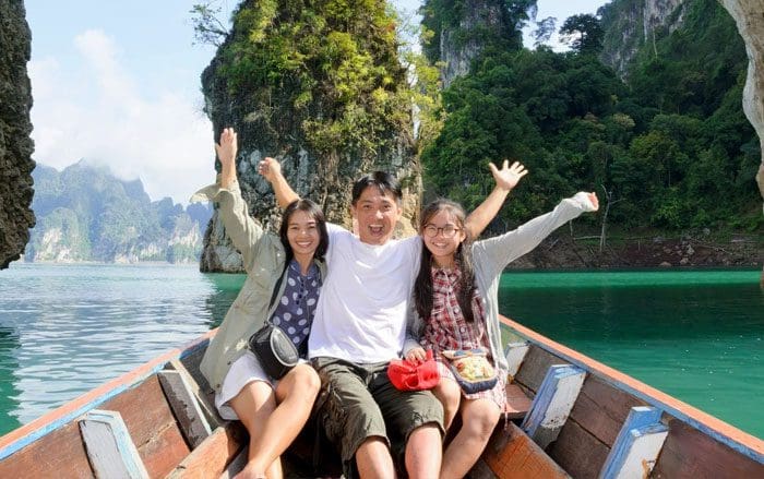 Three people on a boat in the water.